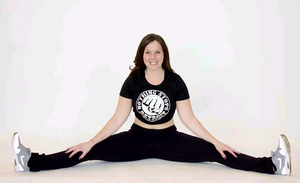 Woman doing the splits while wearing a Nothing Stops Detroit Black with White Logo Performance Tee